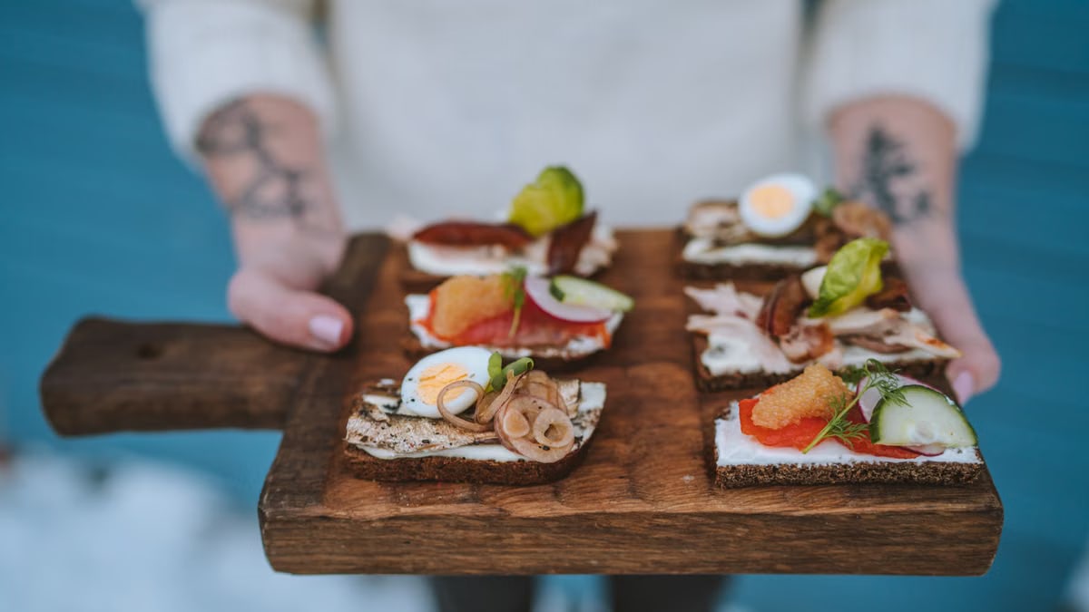 Delicious open-faced sandwiches with various toppings served on a wooden board, showcasing exquisite food styling.